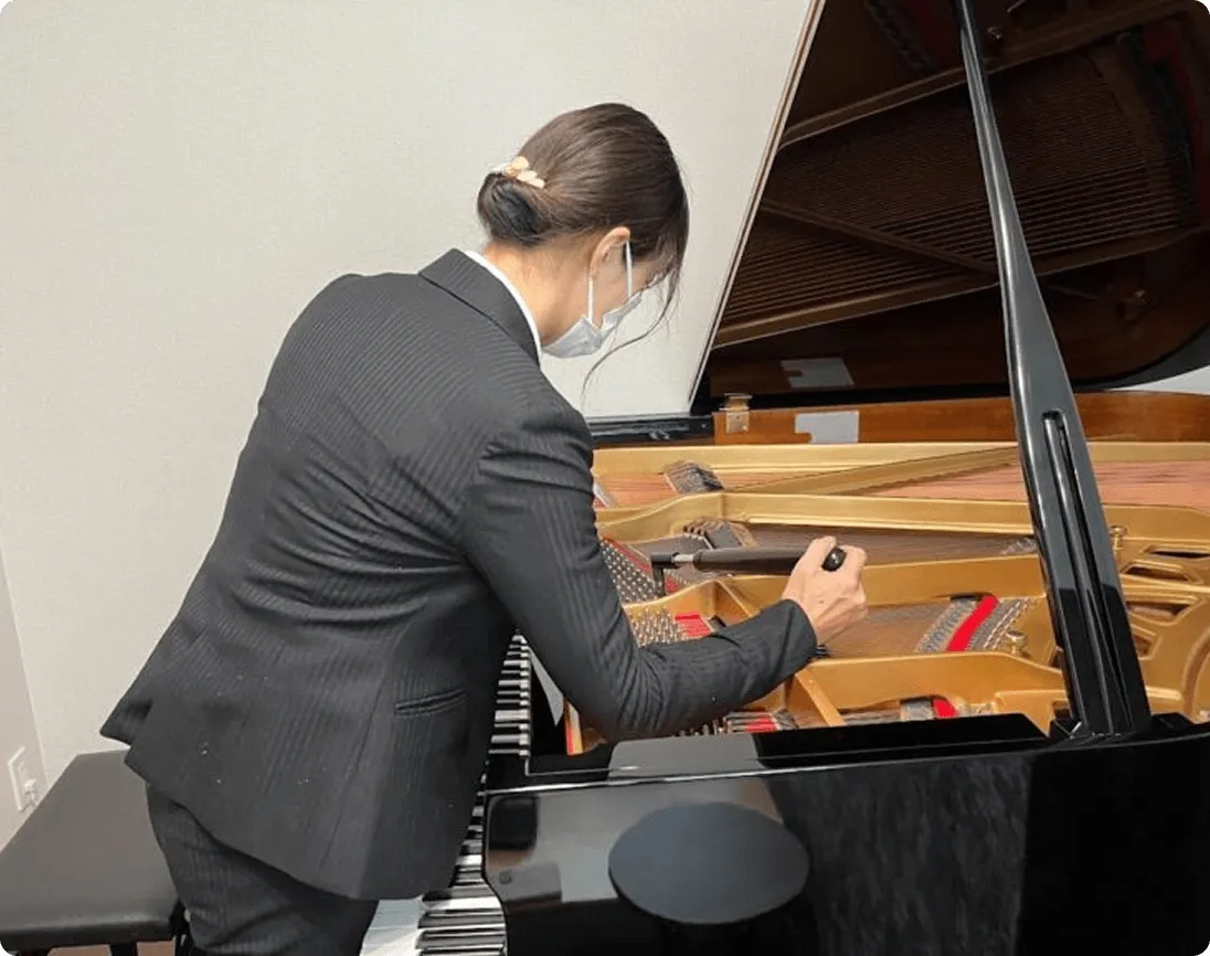 グランドピアノを調律する技術者