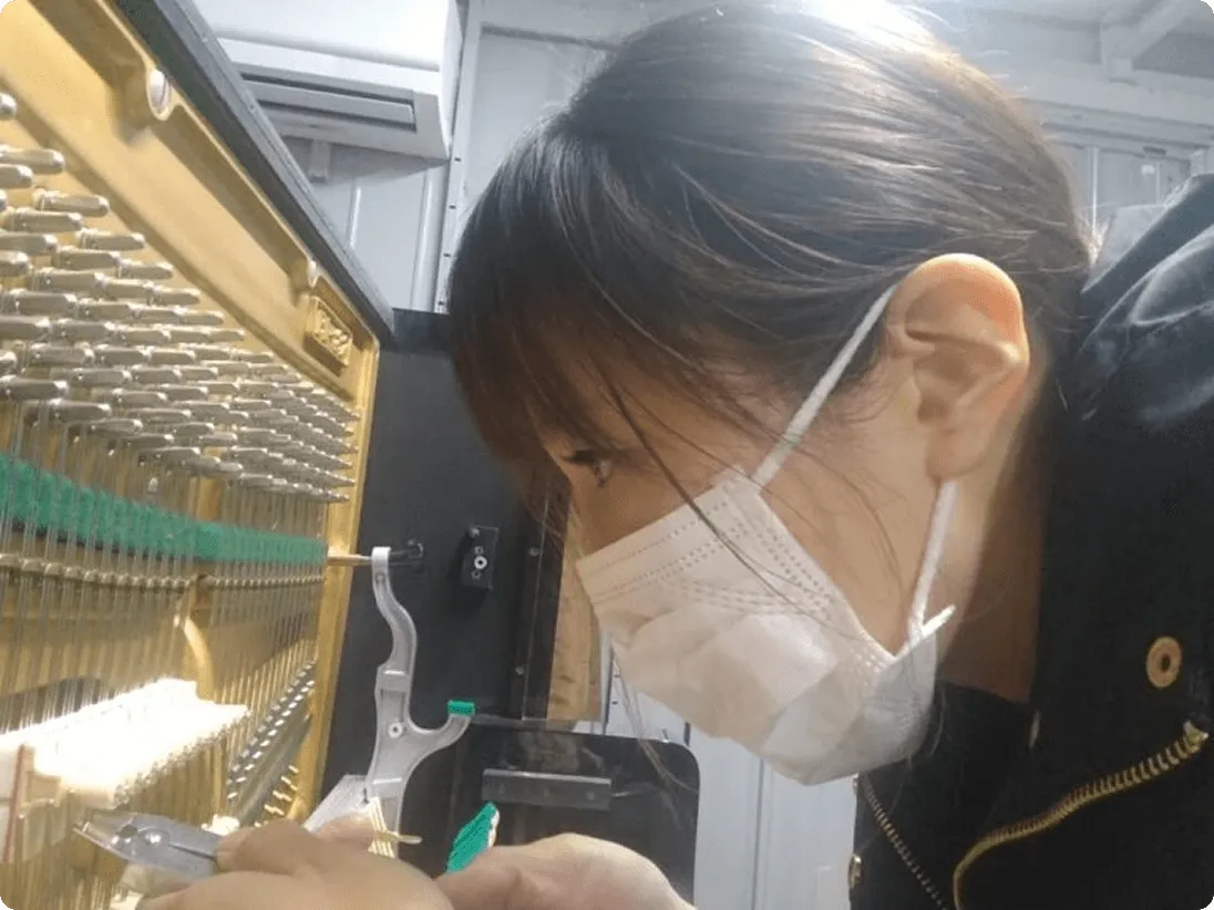 ピアノ内部を調整する技術者